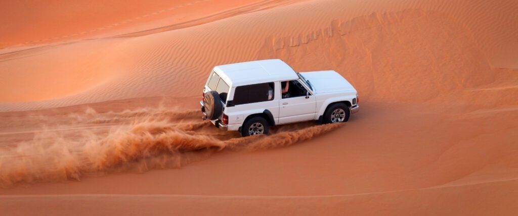 Tourists enjoying dune bashing in 4x4 SUV during Dubai Desert Safari