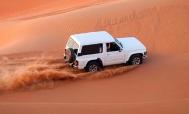 Tourists enjoying dune bashing in 4x4 SUV during Dubai Desert Safari
