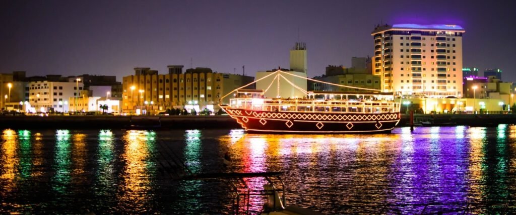 Traditional wooden dhow cruising through Dubai Marina with glittering skyscrapers in the background