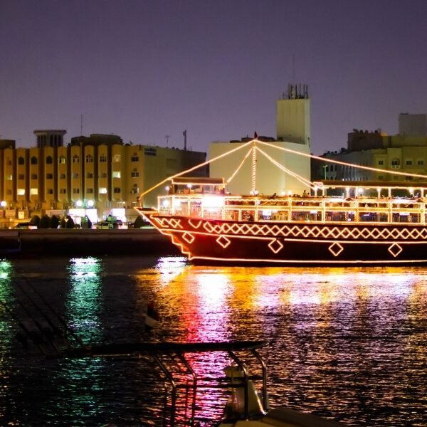Traditional wooden dhow cruising through Dubai Marina with glittering skyscrapers in the background